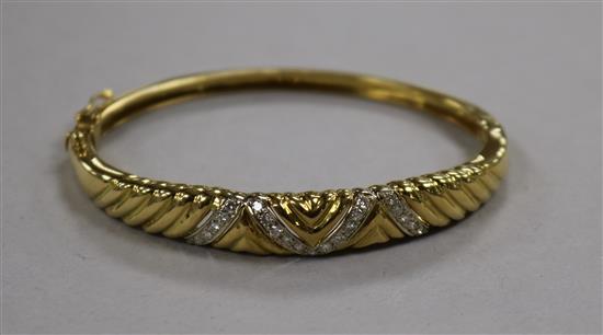 A modern 18ct gold and diamond set hinged bangle.